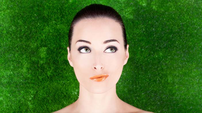 Woman looking thoughtful against green background