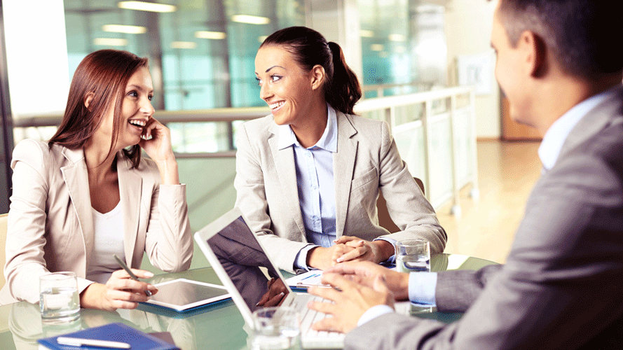 Two women smiling during a work meeting.