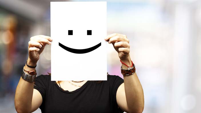 Woman holding paper with happy face.