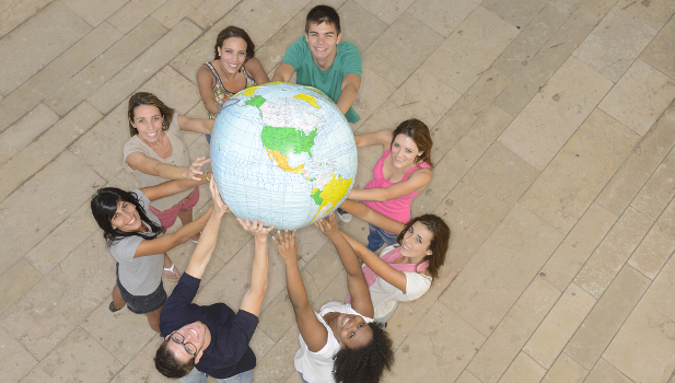 Multiracial group of people holding the Earth