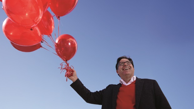Shane Lopez holding a bunch of red balloons