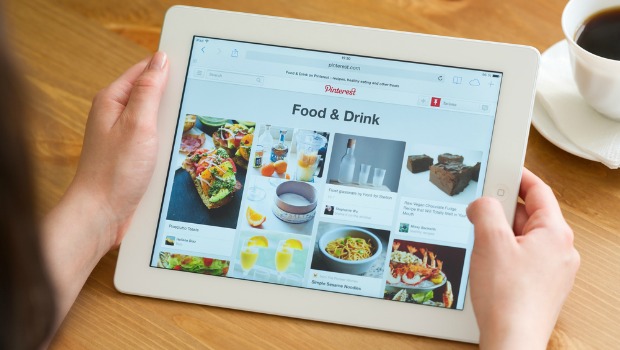 Image of hands holding an iPad with Pinterest displayed