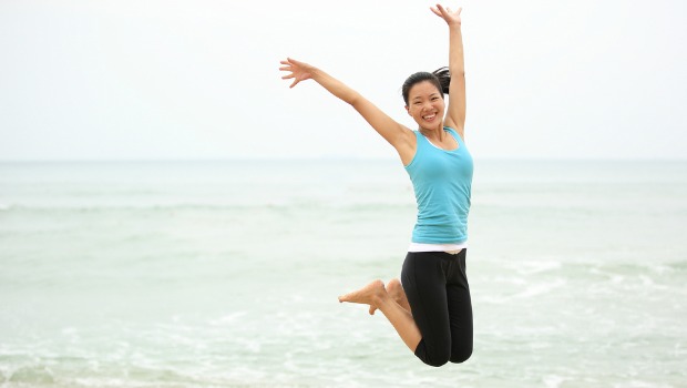 Healthy woman jumping on the beach