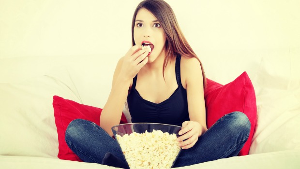 Woman eating popcorn and watching a movie