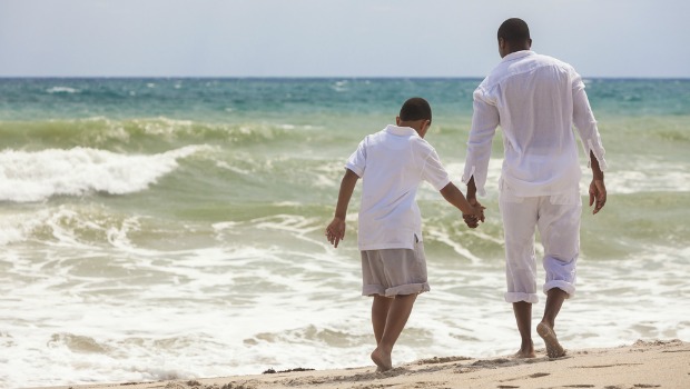 Father and son walking on the beach.