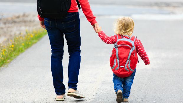 A parent and child walk to school