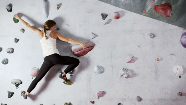 Woman scaling a climbing wall