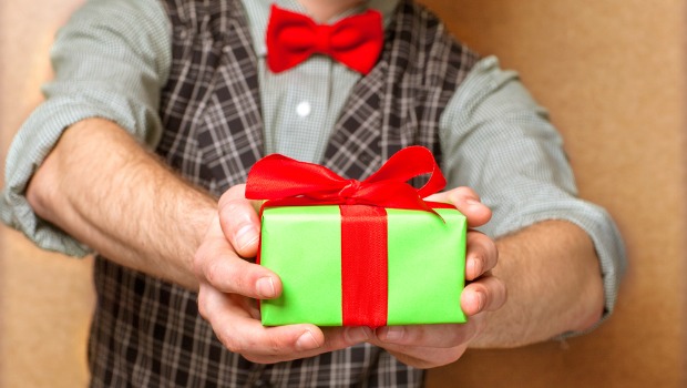Man holding out a small wrapped present.
