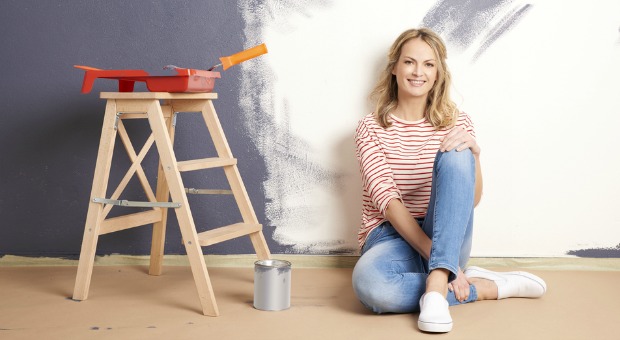 Woman painting walls of her home.