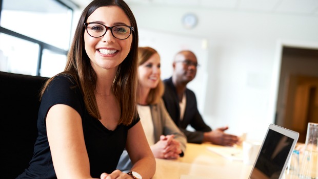 Smiling woman with colleagues in an office.