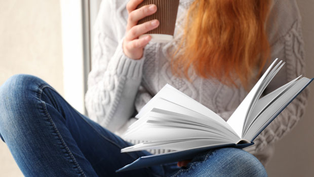 Red-haired woman reading a book.