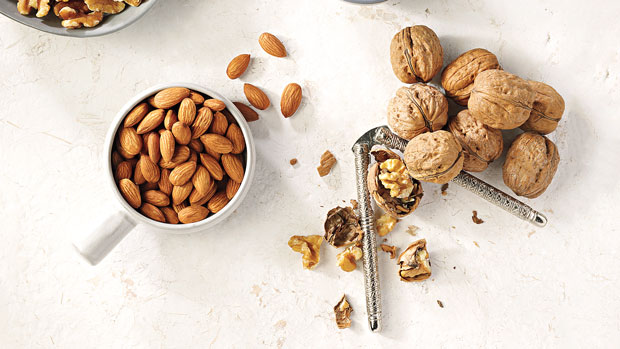 Almonds and whole walnuts being cracked.