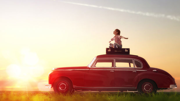 Girl sitting on top a vintage car.