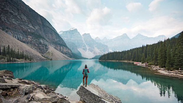 Woman admiring mountains and lake.