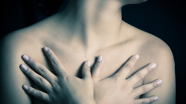Image of woman embracing her chest.