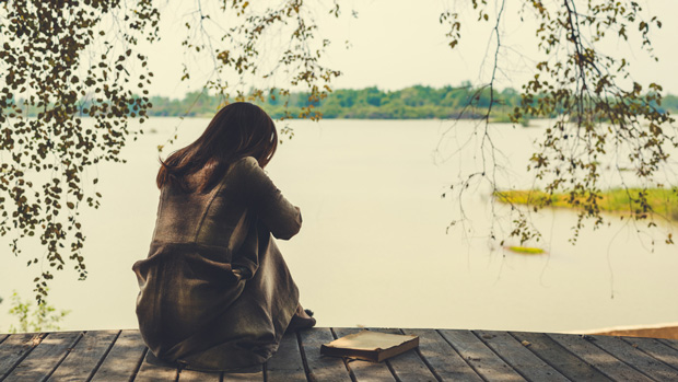 Depressed woman by a lake.