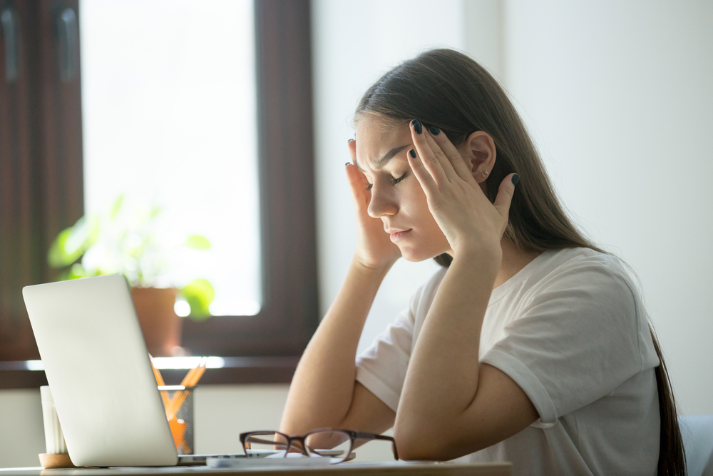 Stress and headache behind laptop on job. Overwork, distress, negative emotions concept