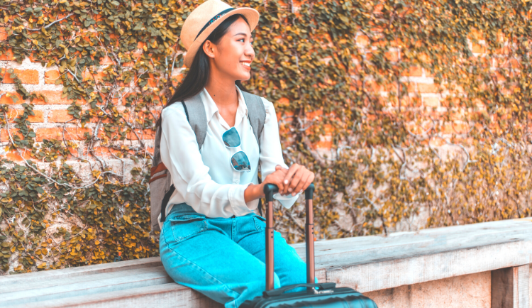 Young woman smiling with her luggage